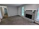 Inviting living room featuring plush carpeting, a stone fireplace, and ample natural light at 3900 Ferncliff Rd, Snellville, GA 30039