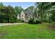 Well-manicured lawn surrounds this traditional home with neutral exterior paint and mature trees at 790 Friendship Church Rd, Douglasville, GA 30134