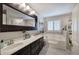 A bathroom featuring a double vanity, a dark wood framed mirror, and a luxurious soaking tub at 263 Bennett Farms Trl, Acworth, GA 30102