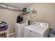 A compact laundry room with a modern washer and dryer set and open shelving at 263 Bennett Farms Trl, Acworth, GA 30102