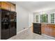 Traditional kitchen featuring wooden cabinets, black appliances, and granite countertops with natural lighting at 3902 Robin Court Ct, Acworth, GA 30101