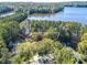 Aerial view showcases waterfront property with mature trees, landscaping and lake views at 504 Telfair Park, Peachtree City, GA 30269