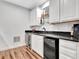 Elegant bar features white cabinets, dark countertops, stainless steel fridge, sink and bar stools at 504 Telfair Park, Peachtree City, GA 30269