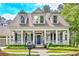 Home with classic covered front porch, white columns, blue shutters, and manicured landscaping at 504 Telfair Park, Peachtree City, GA 30269