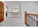 Upstairs hallway with wood railing, iron balusters, plush carpet, and a modern chandelier provides a spacious and elegant feel at 504 Telfair Park, Peachtree City, GA 30269
