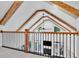 Open loft area with vaulted ceilings, wood beams, black railing, and a view of the downstairs fireplace and French doors at 504 Telfair Park, Peachtree City, GA 30269