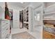 Spacious walk-in closet with custom shelving, drawers, and ample hanging space leading to a bright, elegant bathroom at 504 Telfair Park, Peachtree City, GA 30269
