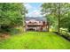 Expansive backyard view with deck, lush lawn, and mature trees creates a serene outdoor setting at 5870 Shadewater Dr. Dr, Cumming, GA 30041