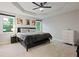 Spacious main bedroom with tray ceiling, windows overlooking the backyard, and neutral color palette at 5870 Shadewater Dr. Dr, Cumming, GA 30041