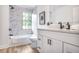 Modern bathroom features white cabinets, marble tile, and a shower-tub combo at 911 Oakland Sw Dr, Atlanta, GA 30310