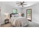 Cozy bedroom with neutral carpet, gray upholstered headboard, ceiling fan, and natural lighting at 911 Oakland Sw Dr, Atlanta, GA 30310