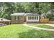 Charming brick home with a well-manicured front lawn and mature trees at 911 Oakland Sw Dr, Atlanta, GA 30310
