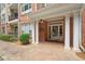 Close-up of a brick building entrance with white columns and a well-manicured garden at 2303 Stratford Commons Commons, Decatur, GA 30033