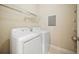 A well-lit laundry room featuring a white washer, dryer, and shelving for storage at 2303 Stratford Commons Commons, Decatur, GA 30033