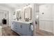Bright bathroom with dual sinks, blue cabinets, and modern lighting fixtures at 4392 Windsor Oaks Cir, Marietta, GA 30066