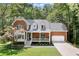 Traditional brick home with a manicured front yard, a covered porch, and an attached garage at 4392 Windsor Oaks Cir, Marietta, GA 30066