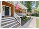 Charming brick home with a covered front porch, white railings, and an inviting entrance at 4392 Windsor Oaks Cir, Marietta, GA 30066