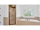 Bathroom featuring soaker tub, separate shower and bright window at 511 Millwood Ct, Canton, GA 30114