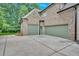 View of a two-car garage with green doors and brick siding at 511 Millwood Ct, Canton, GA 30114
