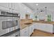 A bright kitchen features white cabinets, granite countertops, stainless steel appliances, and hardwood floors at 511 Millwood Ct, Canton, GA 30114