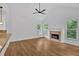 Living room with hardwood floors, fireplace, modern lighting, and large windows with shutters at 511 Millwood Ct, Canton, GA 30114