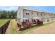 Rear exterior of home with outdoor deck and patio furniture and grassy backyard at 2700 Norwich Trce, Snellville, GA 30078