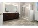 Bathroom featuring dual sinks, a glass shower, and wood look flooring at 2700 Norwich Trce, Snellville, GA 30078