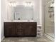 Well-lit bathroom featuring a double vanity with dark wood cabinets and a glass-enclosed shower at 2700 Norwich Trce, Snellville, GA 30078