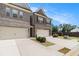 Side view of the two-story townhome showing the driveway, landscaping, and fenced backyard at 2700 Norwich Trce, Snellville, GA 30078