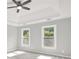 Light-filled bedroom features a ceiling fan, tray ceiling, and two windows offering natural light at 4955 Day Lily Nw Way, Acworth, GA 30102