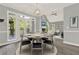 Elegant dining room with large windows, a modern chandelier, and an open view to the living area at 4955 Day Lily Nw Way, Acworth, GA 30102