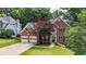 Exterior shot of a two-story brick home with a well-manicured lawn and mature trees at 4955 Day Lily Nw Way, Acworth, GA 30102
