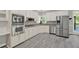 Well-lit kitchen featuring white cabinetry, stainless steel appliances and gray flooring at 4955 Day Lily Nw Way, Acworth, GA 30102