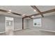 Living room featuring wood beam ceiling, window with blinds and neutral color palette at 4955 Day Lily Nw Way, Acworth, GA 30102