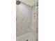 Modern shower with floor-to-ceiling marble-look tiles, a built-in niche, and a corner seat at 4955 Day Lily Nw Way, Acworth, GA 30102