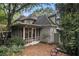 Picturesque backyard with screened porch, brick patio, and lush greenery, offering a private and serene outdoor space at 80 Stratford Ne Pl, Atlanta, GA 30342