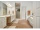 Bathroom with tile floor, double sink vanity with white cabinets, shower, toilet, and step up to the tub at 80 Stratford Ne Pl, Atlanta, GA 30342