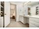 Bathroom with a large mirror, white cabinets, an open doorway to the bedroom, and ample countertop space at 80 Stratford Ne Pl, Atlanta, GA 30342