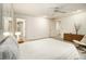 Bedroom with plush carpeting, a ceiling fan, large doors, and a view of an adjacent staircase at 80 Stratford Ne Pl, Atlanta, GA 30342