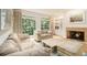 Cozy living room featuring a fireplace, large windows, and hardwood floors at 80 Stratford Ne Pl, Atlanta, GA 30342