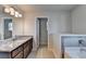 Bright bathroom featuring a granite countertop, double vanity, and soaking tub at 829 Still Hill Ln, Lawrenceville, GA 30045