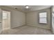 An empty bedroom showing neutral-colored carpet, two windows, and a door at 829 Still Hill Ln, Lawrenceville, GA 30045