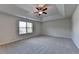 Spacious bedroom featuring a tray ceiling, neutral carpeting, and a large window for natural light at 829 Still Hill Ln, Lawrenceville, GA 30045