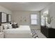 Bedroom featuring neutral walls and carpet, a large window, and decorative bedside lamps at 829 Still Hill Ln, Lawrenceville, GA 30045
