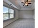 Bright bedroom featuring a tray ceiling, neutral carpeting, and a large window with a scenic view at 829 Still Hill Ln, Lawrenceville, GA 30045