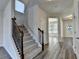 Inviting entryway with staircase and wood railing, leading to a bright living space with natural light at 829 Still Hill Ln, Lawrenceville, GA 30045