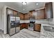 Modern kitchen features stainless appliances, granite counters, and dark cabinets at 829 Still Hill Ln, Lawrenceville, GA 30045