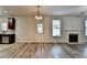 Open-concept living room with fireplace, view to kitchen with dark cabinetry at 829 Still Hill Ln, Lawrenceville, GA 30045