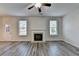 Bright living room featuring a fireplace, two large windows and a ceiling fan at 829 Still Hill Ln, Lawrenceville, GA 30045