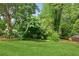 Spacious and well-manicured backyard with a lush green lawn, mature trees, and a serene garden, perfect for relaxation at 878 Treadstone Overlook, Suwanee, GA 30024